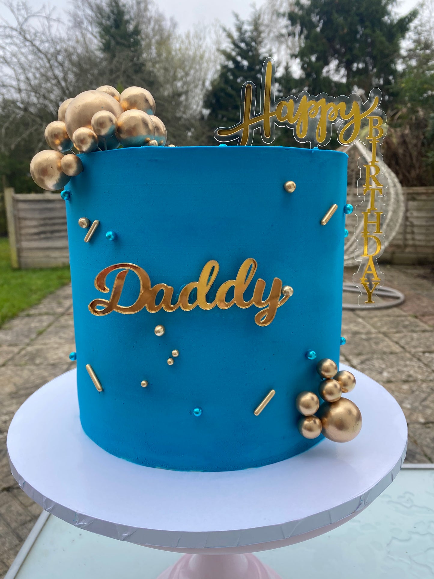 Deep blue cake with gold ball decorations