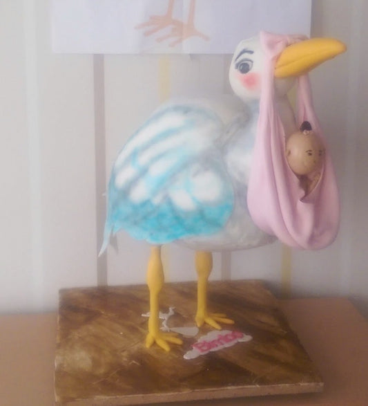 Stork carrying a baby cake
